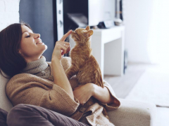 woman cuddling kitten in the sofa