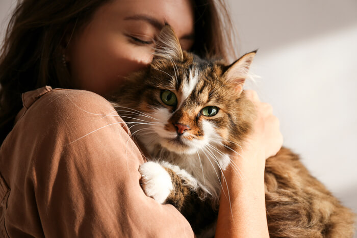 Mujer sosteniendo y abrazando tiernamente a su amado gato