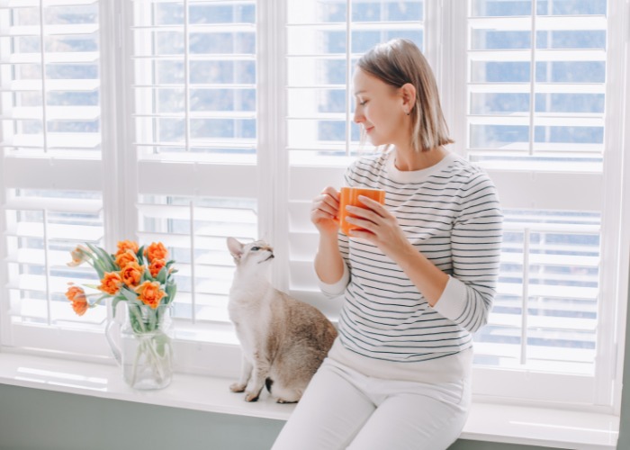 Mujer sentada y conversando con su gato