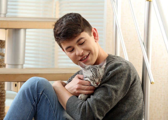 Imagen que captura un momento conmovedor de un niño acariciando suavemente a un gato.