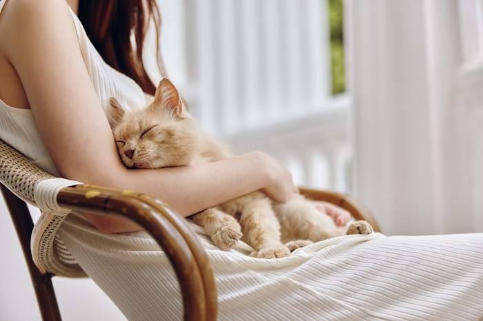 Una mujer disfrutando de un momento de paz con su gato, una conexión serena y reconfortante entre humano y felino.