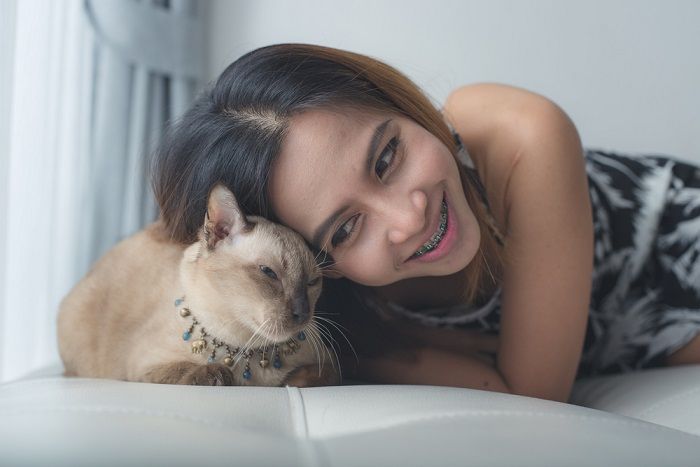 Mujer y gato acostados en el sofá