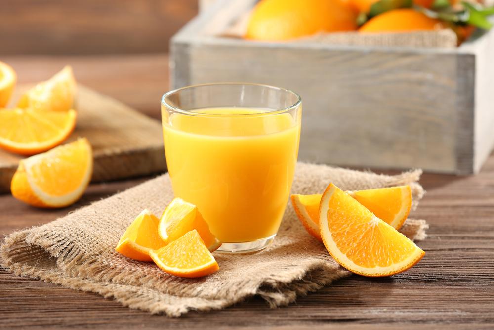 Vaso de jugo de naranja colocado sobre una mesa.