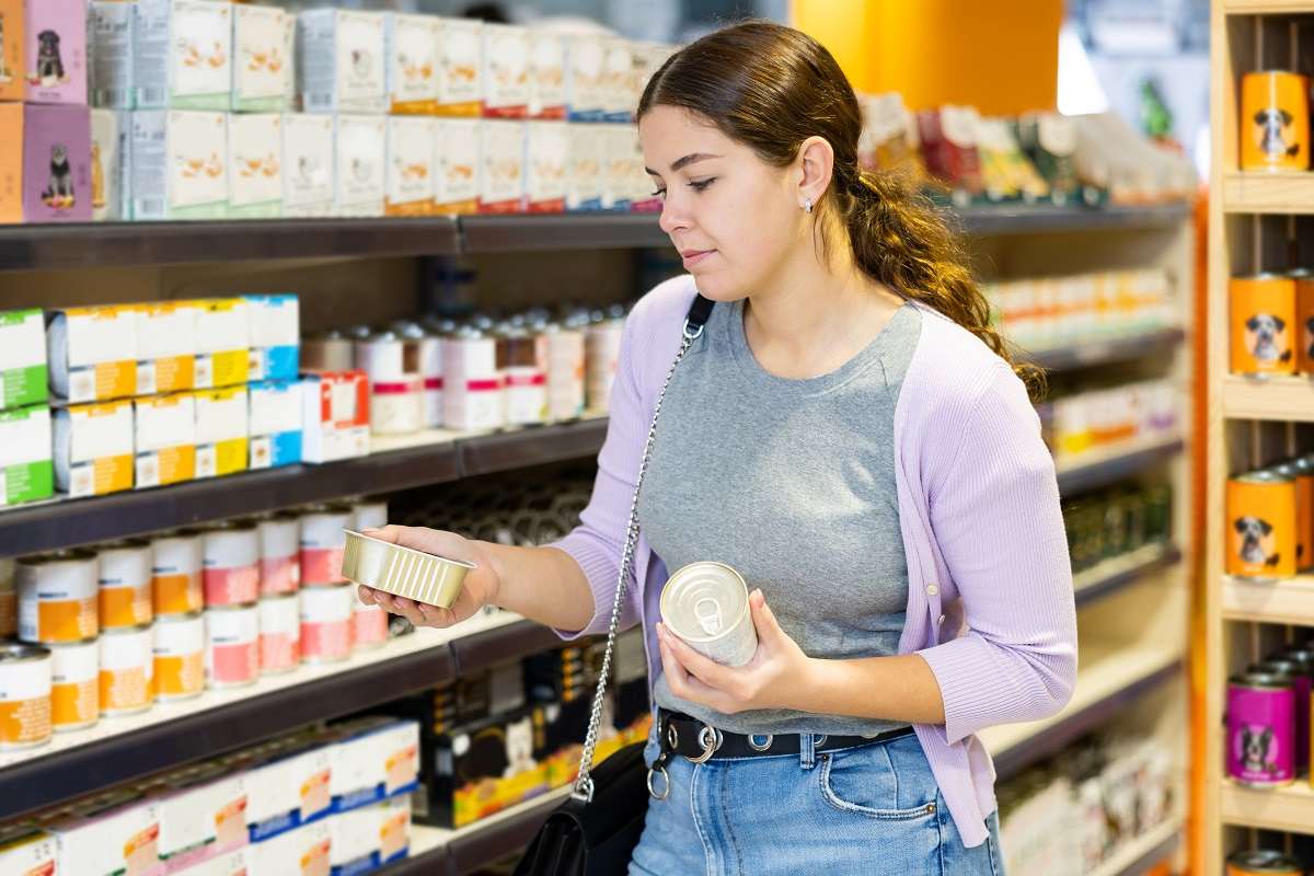 Mujer comprando en el pasillo de comida para mascotas